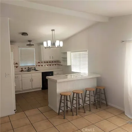 a kitchen with kitchen island granite countertop a stove a sink a dining table and chairs