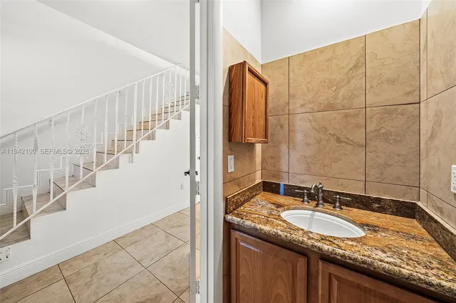 a bathroom with a granite countertop sink and a mirror