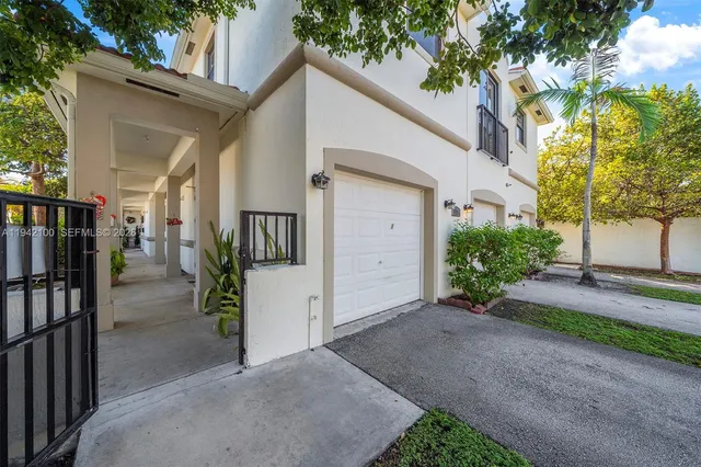 a view of a house with a yard and potted plants