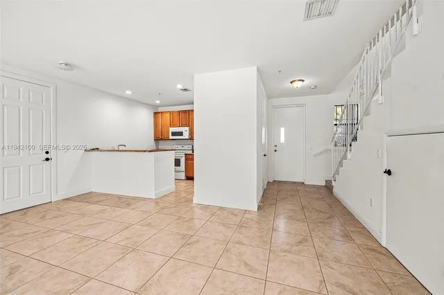 a view of a hallway with closet and windows