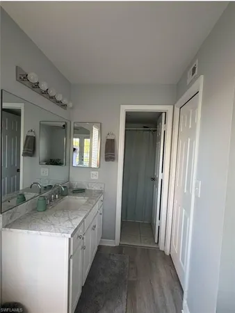 a bathroom with a granite countertop sink and a mirror