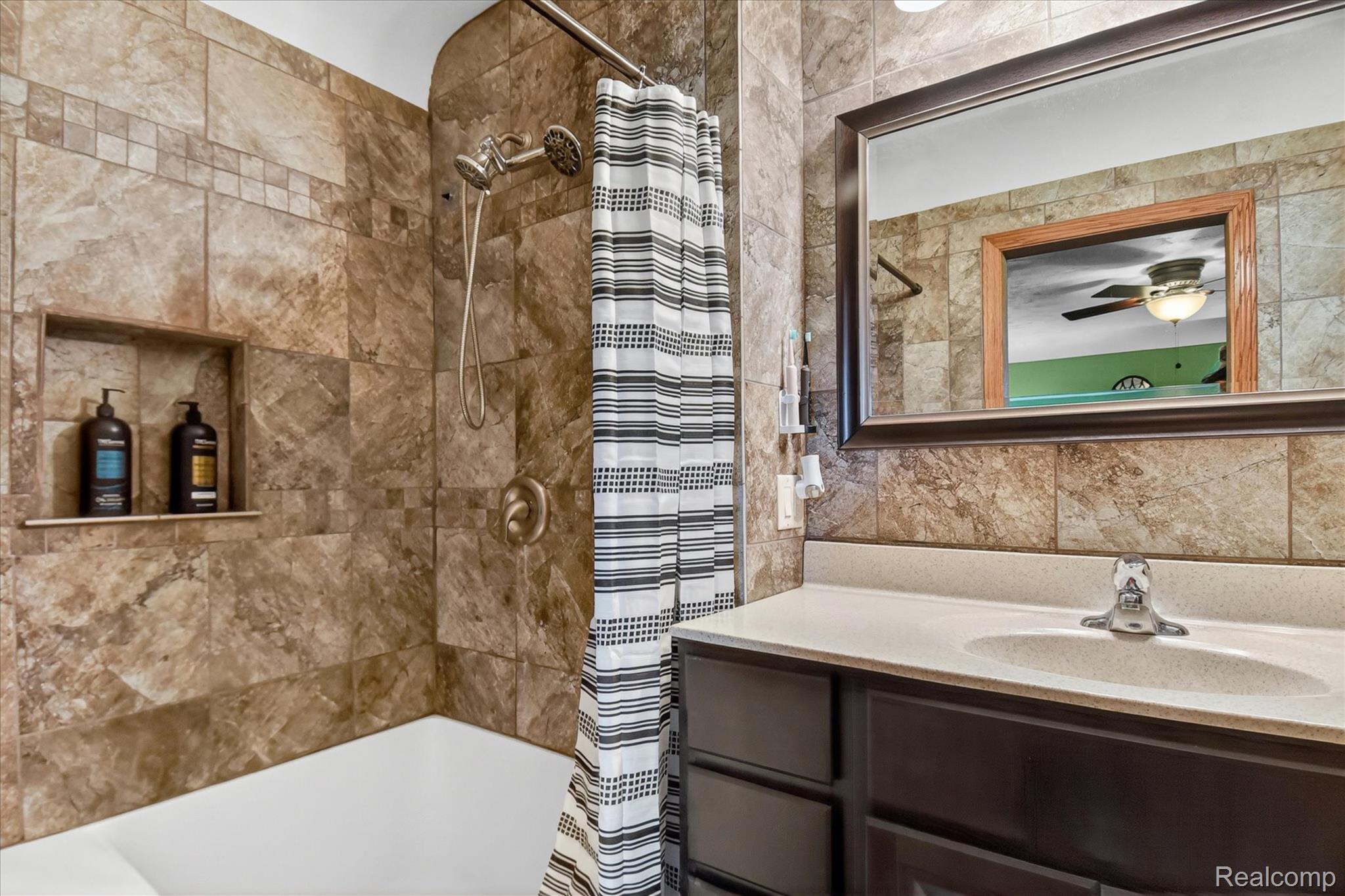 3949 West Burns Line Road Brown City, MI 48416 - Photo 32 of 70 Bathroom featuring a full tub/shower combination with tile surround and an integrated shower niche