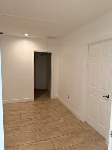 a patio with table and chairs and potted plants