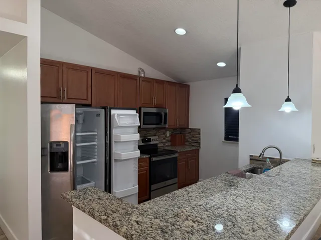 a kitchen with a refrigerator sink and stainless steel appliances