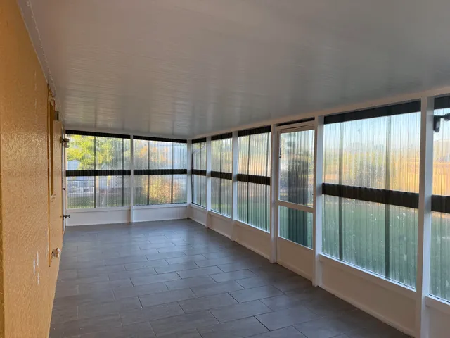 a view of an empty room with wooden floor and a balcony