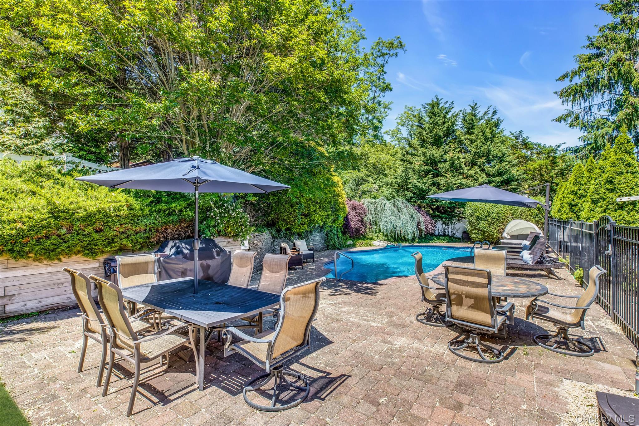 345 Colonial Road Southold, NY 11971 - Photo 37 of 43 a view of a backyard with table and chairs under an umbrella