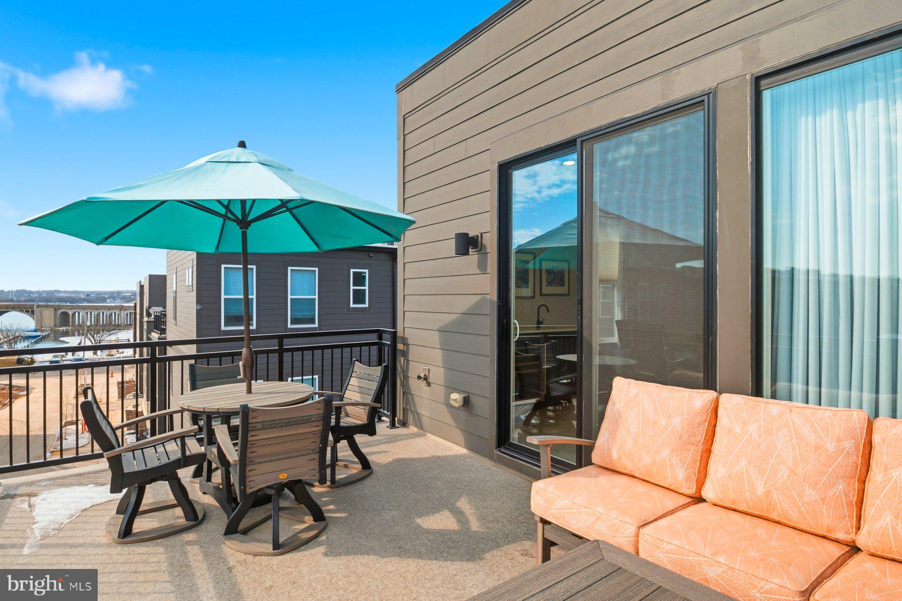 100 Glass Lane Baltimore, MD 21230 - Photo 33 of 36 a patio with a table and chairs under an umbrella
