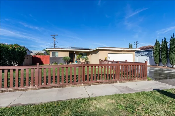 a view of a house with a yard and a fence