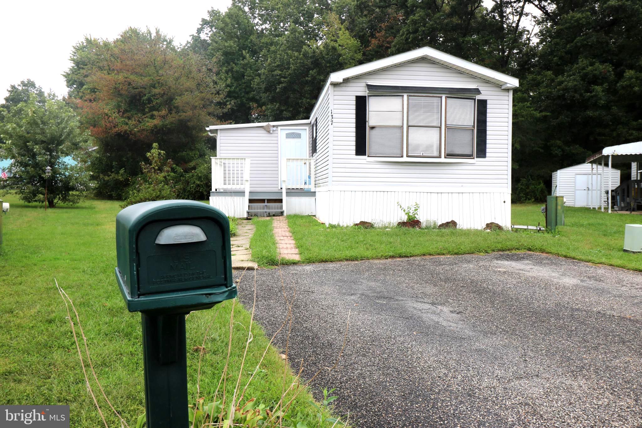 a front view of a house with a yard and trees