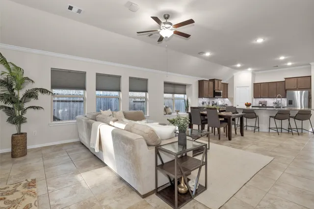 a living room with furniture a dining table and kitchen view
