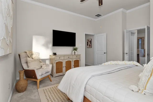 a spacious bedroom with a bed and a flat screen tv