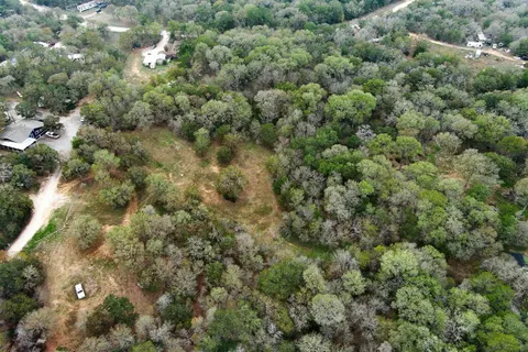 an aerial view of residential houses with outdoor space and trees