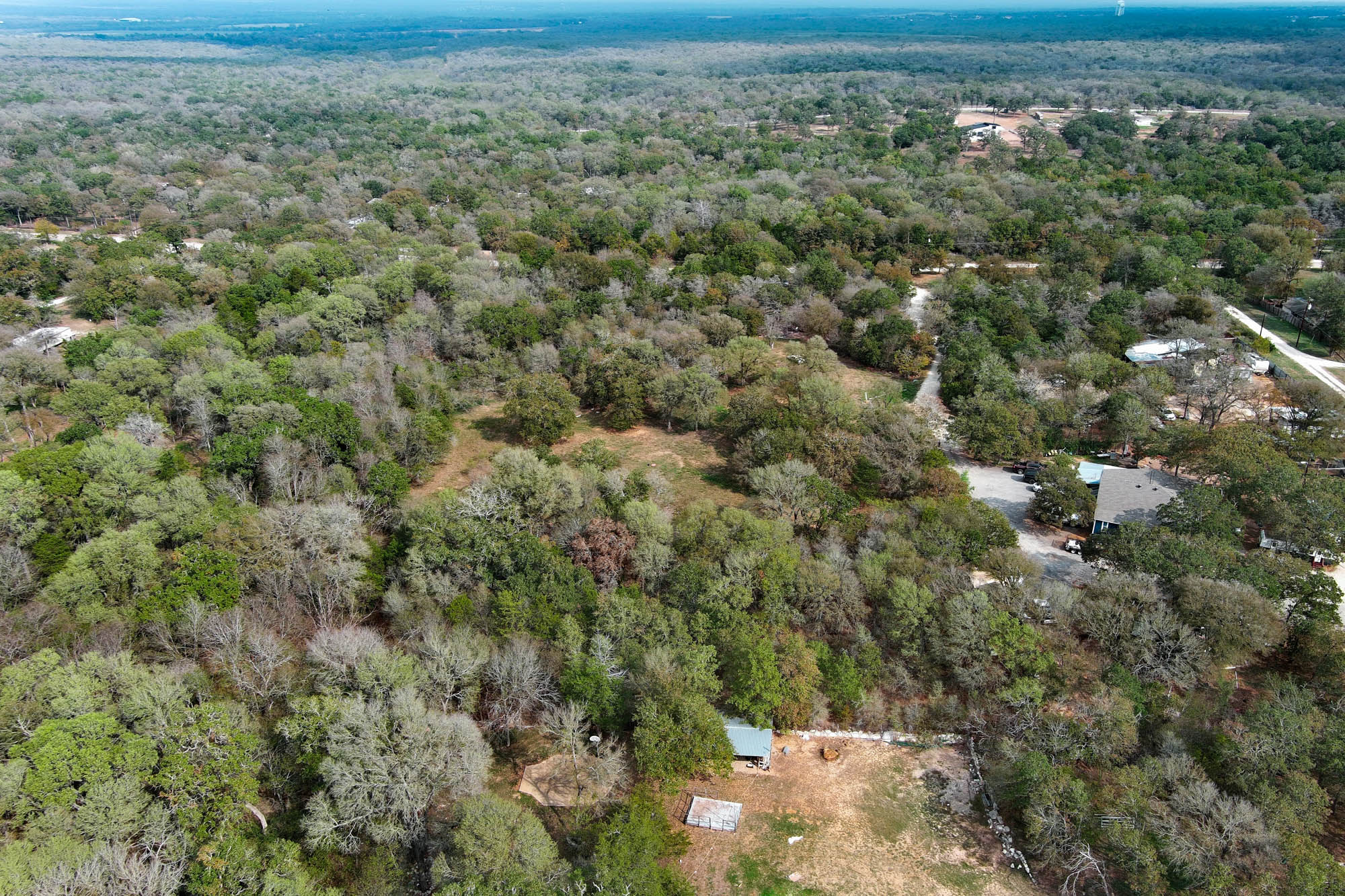 233 The Forest Road Dale, TX 78616 - Photo 5 of 15 Aerial view of property and surrounding area with a forest