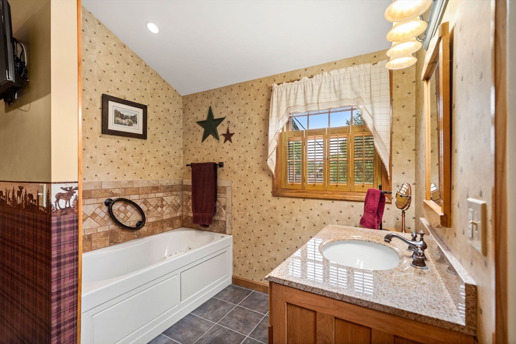 4 Alpha Road Groveland, MA 01834 - Photo 26 of 41 a bathroom with a granite countertop sink a mirror a bathtub and shower