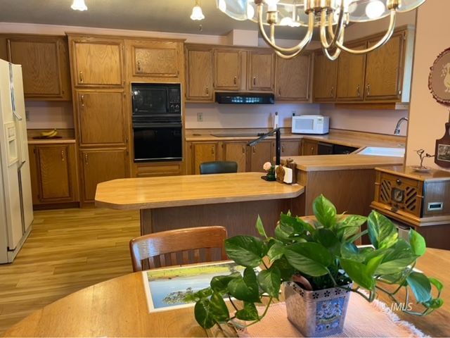 2263 Darby Avenue Bishop, CA 93514 - Photo 6 of 23 a kitchen with stainless steel appliances granite countertop a refrigerator a sink a stove and a wooden floors