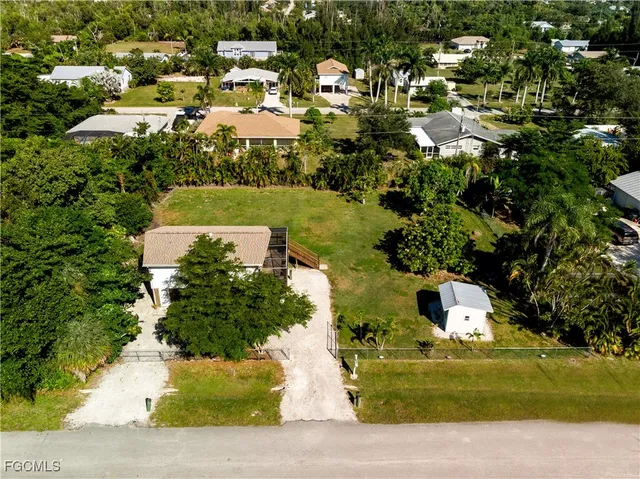 an aerial view of a house with a yard and lake view
