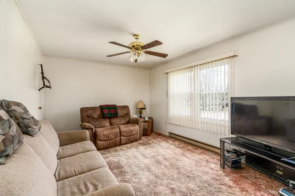 a living room with furniture a flat screen tv and a window