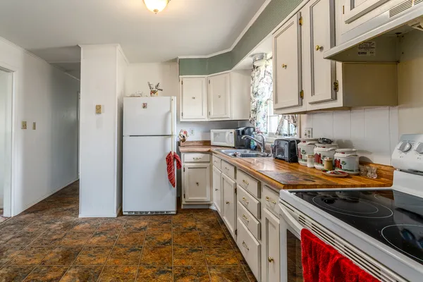 a kitchen with stainless steel appliances granite countertop a refrigerator sink and white cabinets