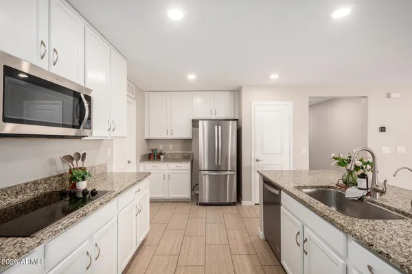 a kitchen with stainless steel appliances granite countertop a refrigerator and a stove top oven