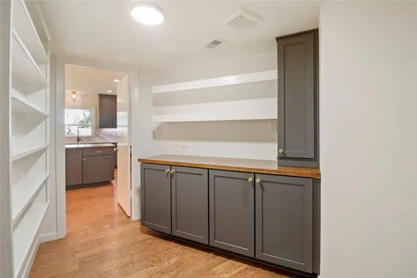 an empty room with wooden floor and fan