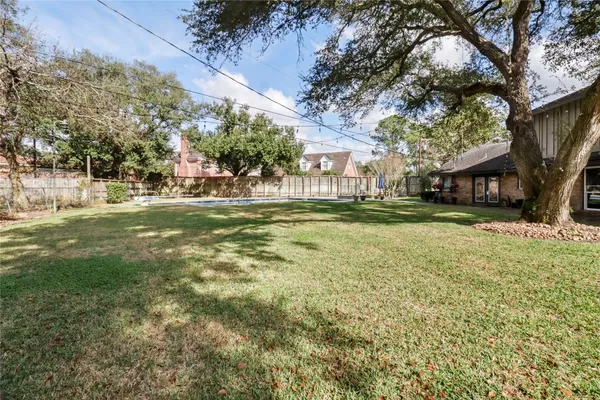 an aerial view of residential house with outdoor space and trees all around