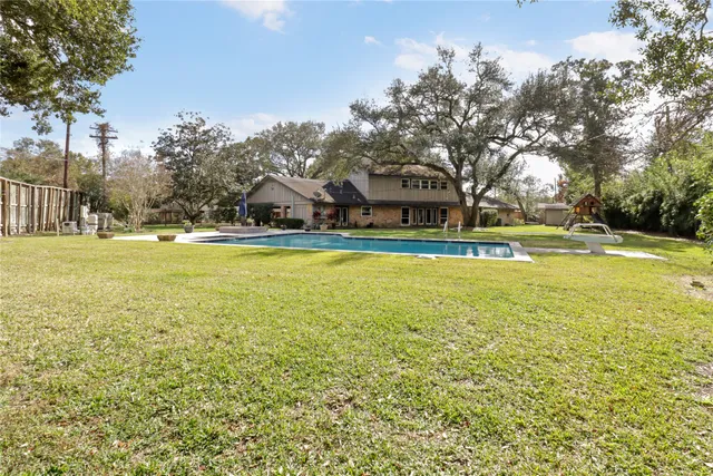 an aerial view of residential house with outdoor space and trees all around