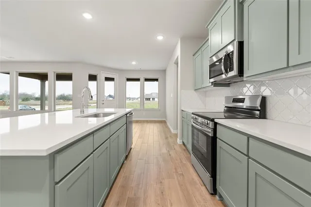 an empty room with wooden floor and ceiling fan