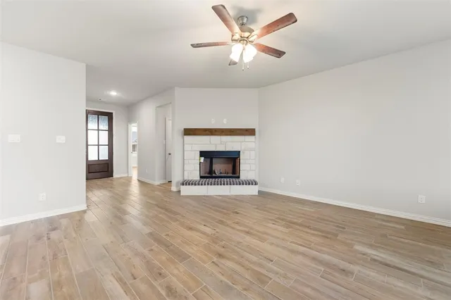 an empty room with windows and ceiling fan