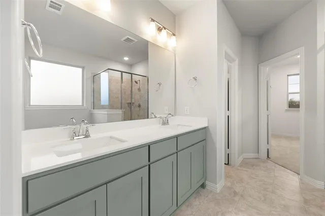 a bathroom with a granite countertop bathtub shower sink vanity and toilet