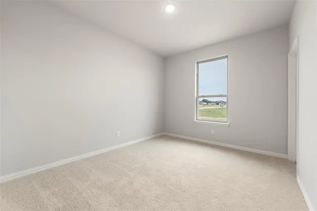a view of an empty room with wooden floor fireplace and a window