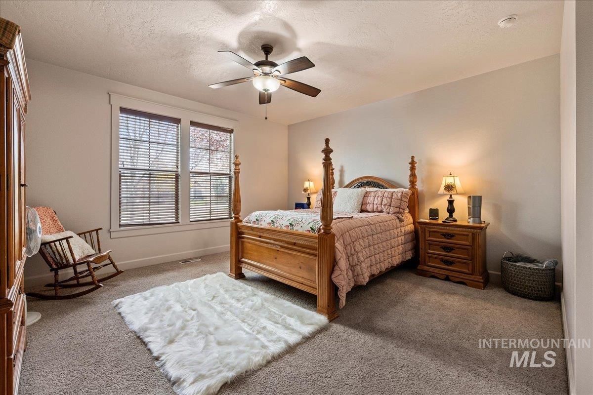 1063 West Hitchcock Street Meridian, ID 83646 - Photo 20 of 50 Carpeted bedroom featuring a textured ceiling and a ceiling fan
