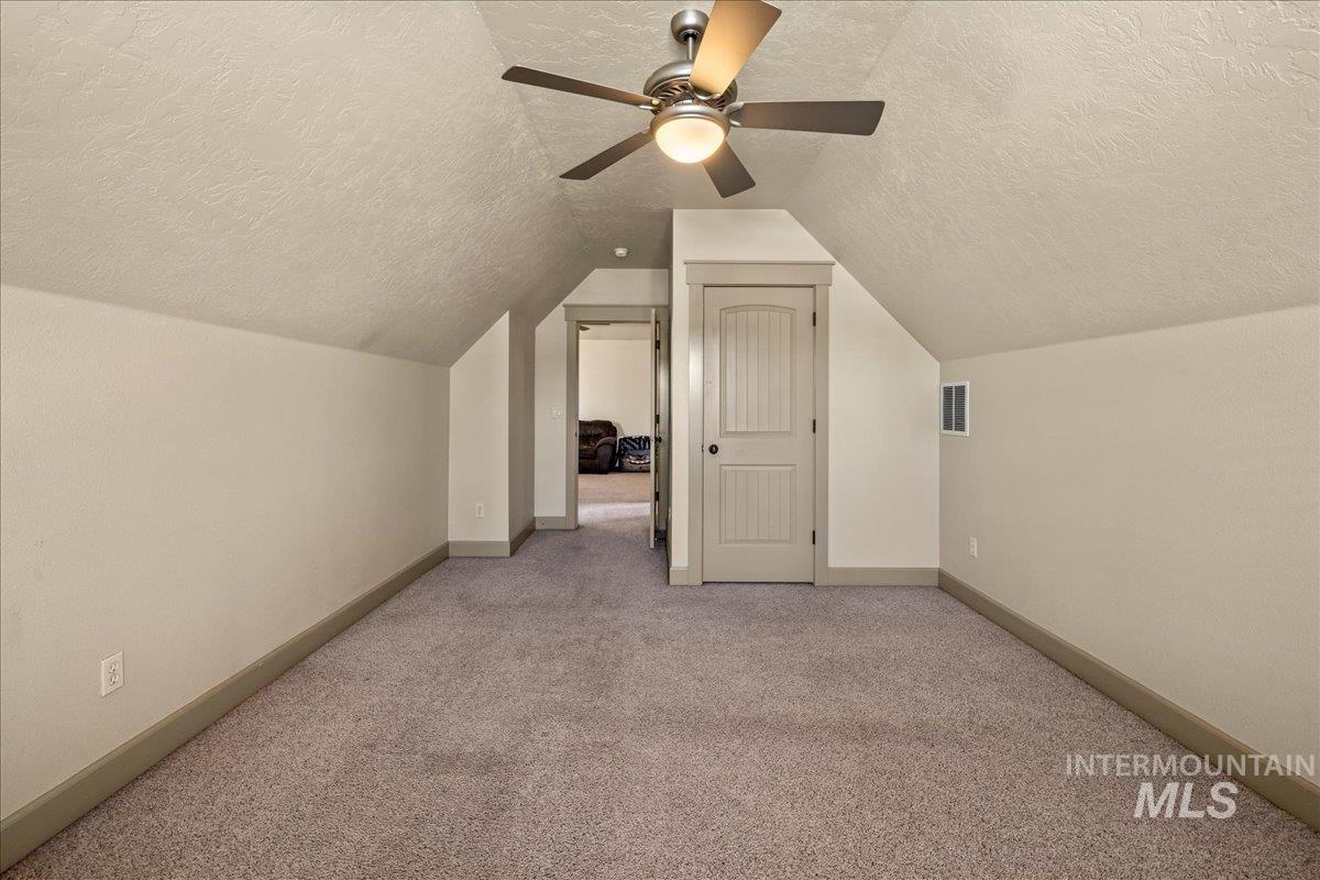 1063 West Hitchcock Street Meridian, ID 83646 - Photo 34 of 50 Bonus room featuring light carpet, a textured ceiling, lofted ceiling, and ceiling fan