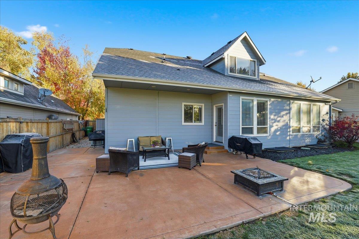 1063 West Hitchcock Street Meridian, ID 83646 - Photo 42 of 50 Rear view of property featuring a patio, roof with shingles, and an outdoor living space with a fire pit