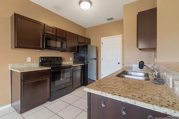 a kitchen with stainless steel appliances granite countertop a sink and a stove