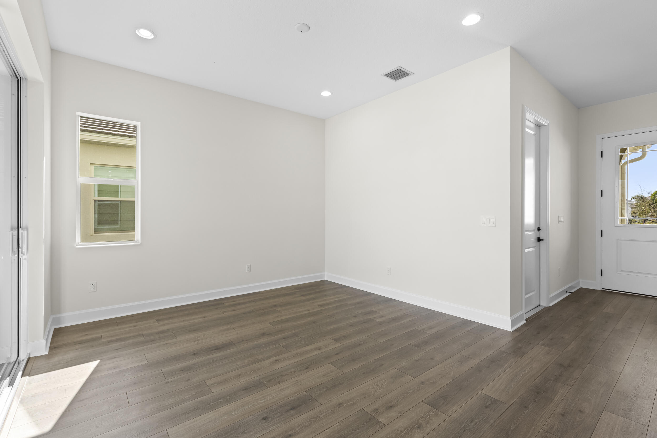 14159 Gray Bark Bend Westlake, FL 33470 - Photo 11 of 87 an empty room with wooden floor and windows