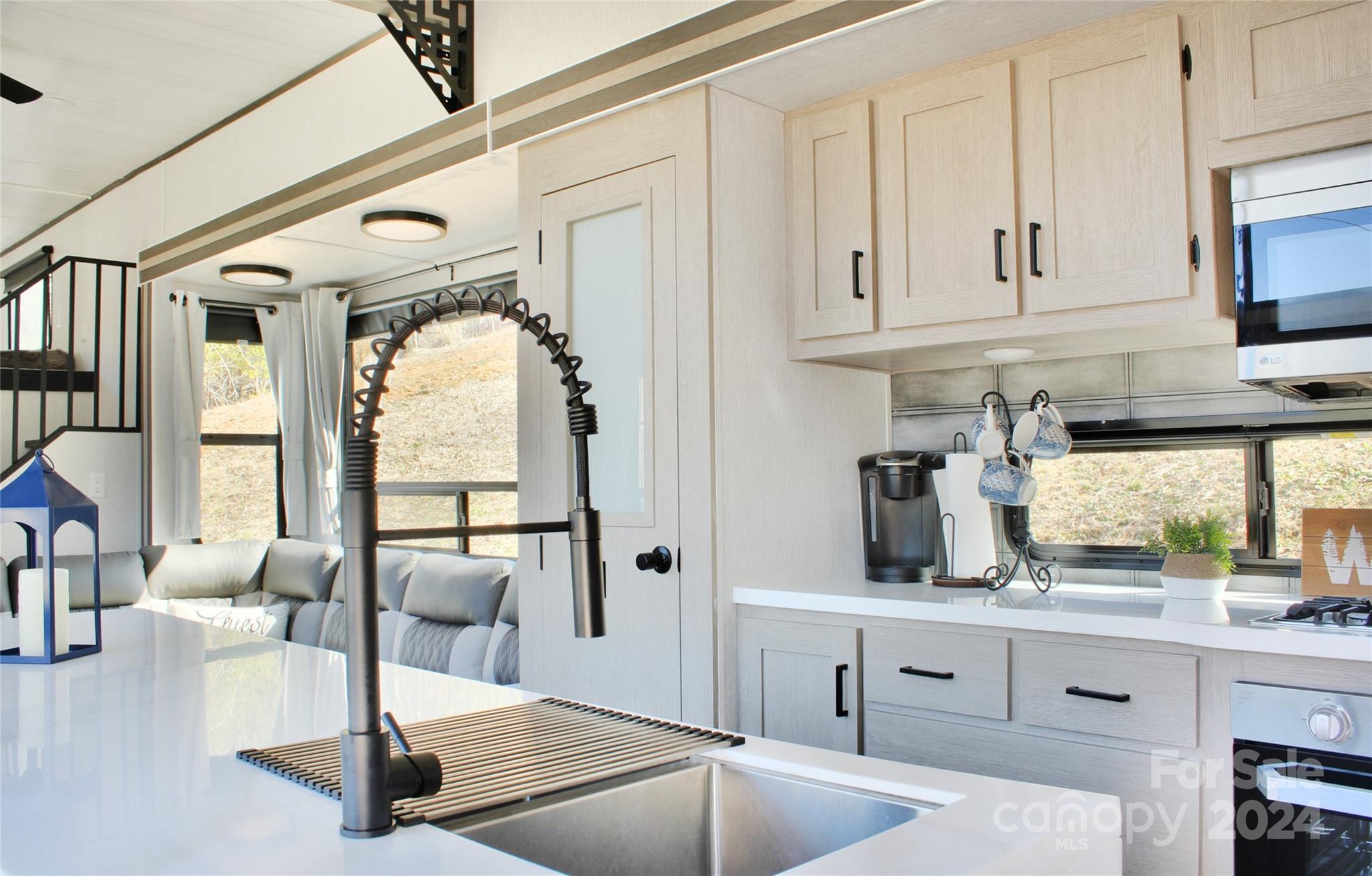 3280 Laurel Valley Road Mars Hill, NC 28754 - Photo 14 of 21 a kitchen with stainless steel appliances granite countertop a stove and white cabinets with wooden floor
