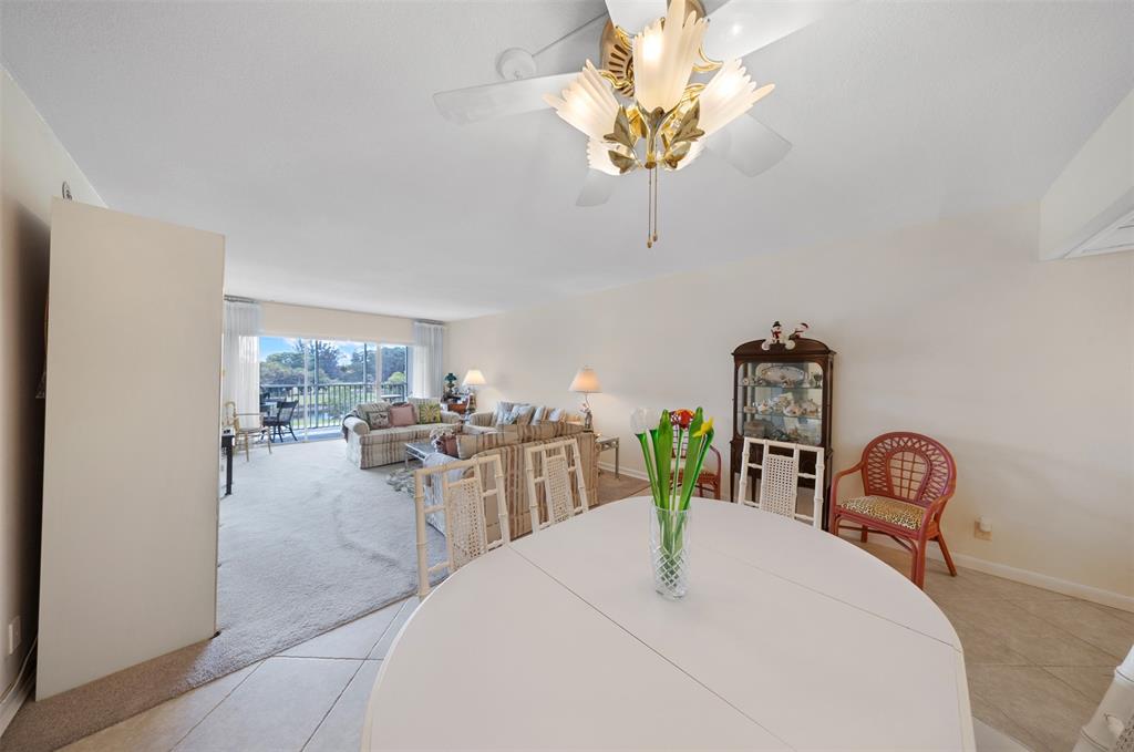 3000 North Palm Aire Drive, Unit 302 Pompano Beach, FL 33069 - Photo 10 of 23 a dining room with furniture a chandelier and window