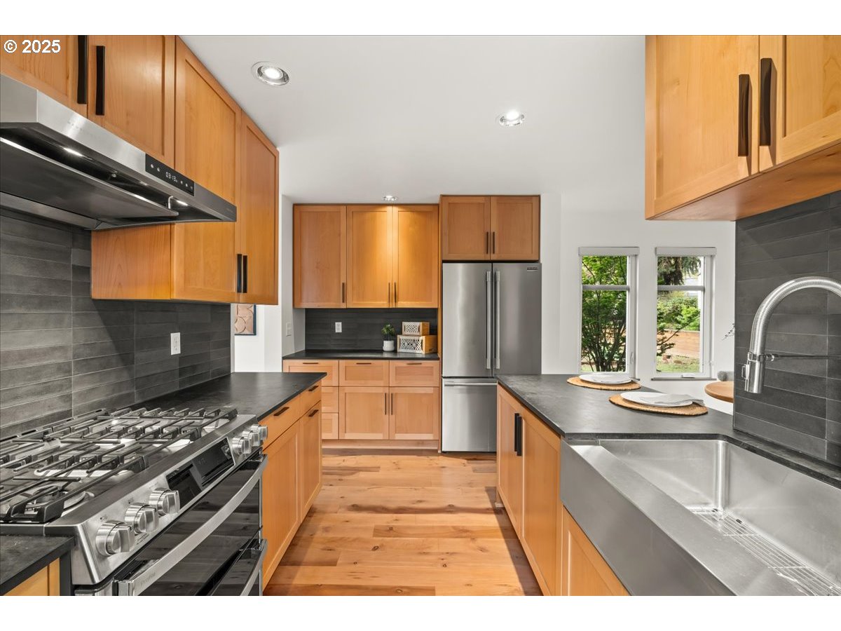 8316 Southeast 7th Avenue Portland, OR 97202 - Photo 12 of 44 a kitchen with stainless steel appliances granite countertop a stove a sink and a refrigerator