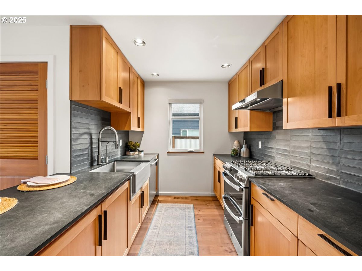 8316 Southeast 7th Avenue Portland, OR 97202 - Photo 10 of 44 a kitchen with stainless steel appliances granite countertop a sink stove and cabinets