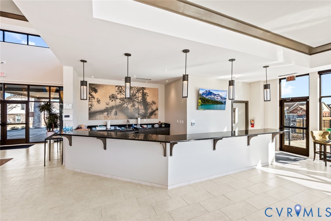 6655 Citory Way, Unit 103 Moseley, VA 23120 - Photo 29 of 48 a kitchen with stainless steel appliances kitchen island granite countertop a stove and white cabinets