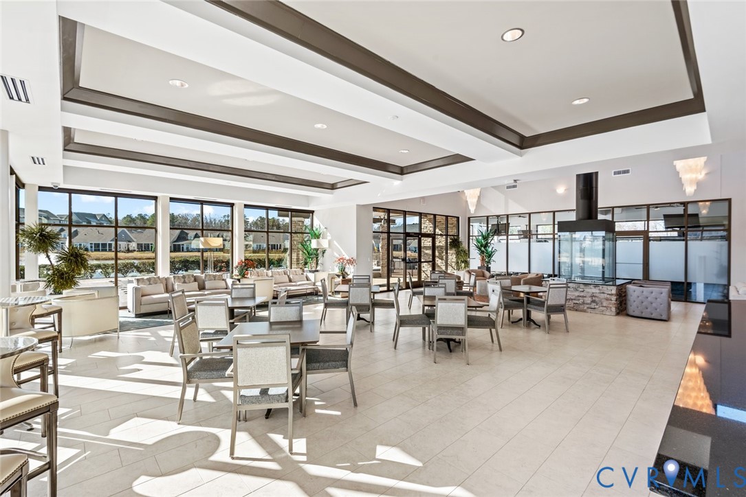 6655 Citory Way, Unit 103 Moseley, VA 23120 - Photo 31 of 48 a room with lots of tables a large window and chairs