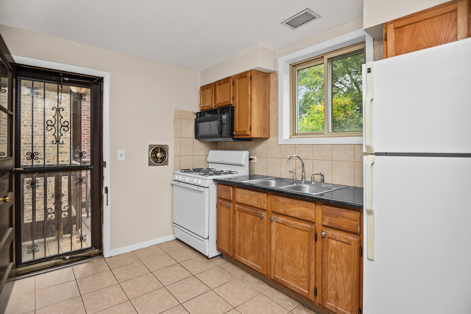 7019 North Ridge Boulevard, Unit 3A Chicago, IL 60645 - Photo 6 of 14 a kitchen with granite countertop a refrigerator sink and cabinets