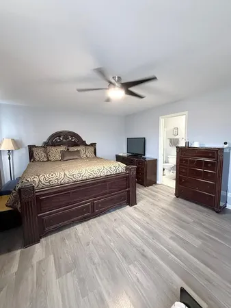 a spacious bedroom with a bed and a dresser