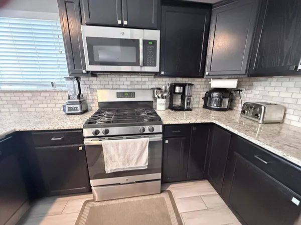 a kitchen with granite countertop cabinets stainless steel appliances and a sink