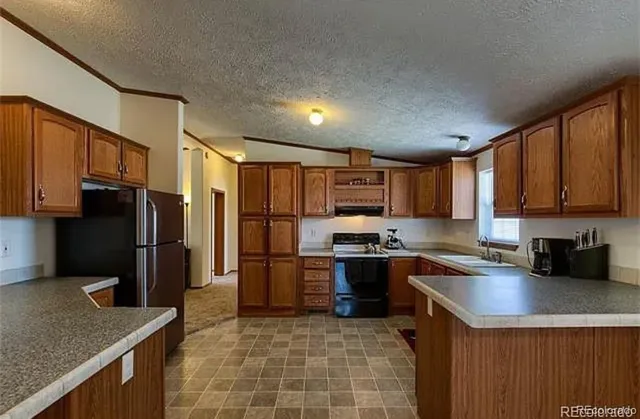 a kitchen with stainless steel appliances granite countertop a sink refrigerator and cabinets