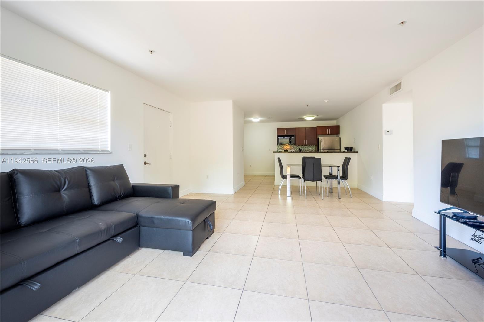 4147 Stirling Road, Unit 301 Dania Beach, FL 33314 - Photo 4 of 12 a living room with furniture and a flat screen tv
