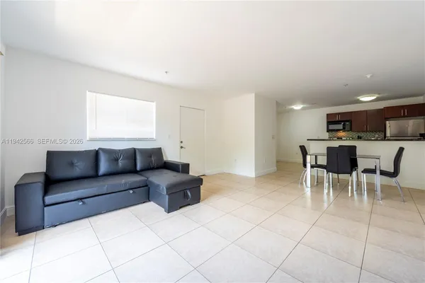 a living room with furniture and a dining table with kitchen view