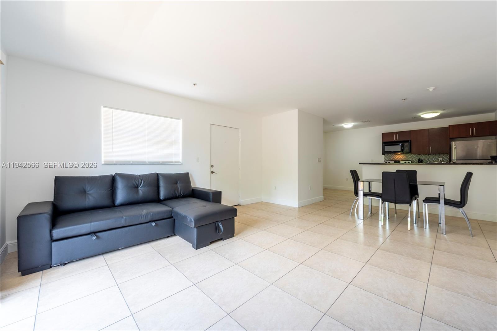 4147 Stirling Road, Unit 301 Dania Beach, FL 33314 - Photo 5 of 12 a living room with furniture and a dining table with kitchen view