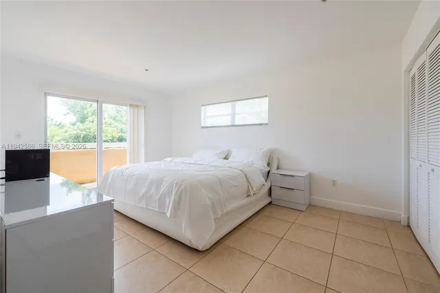 a spacious bedroom with a bed and a large window