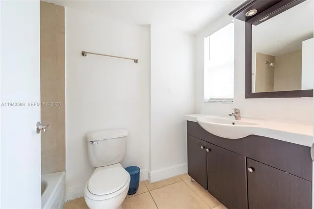 a bathroom with a toilet a sink a mirror and a shower